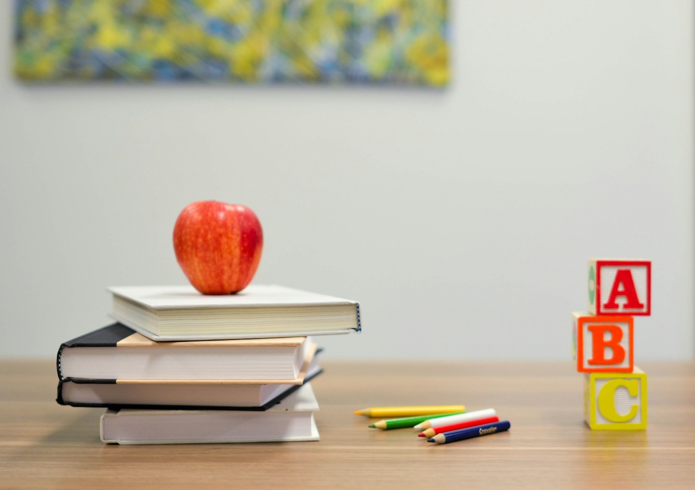 Books, an apple, and learning blocks on a classroom desk